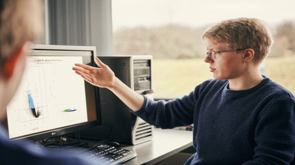 Ein Mann sitzt vor dem Computer und schaut sich Graphen an.