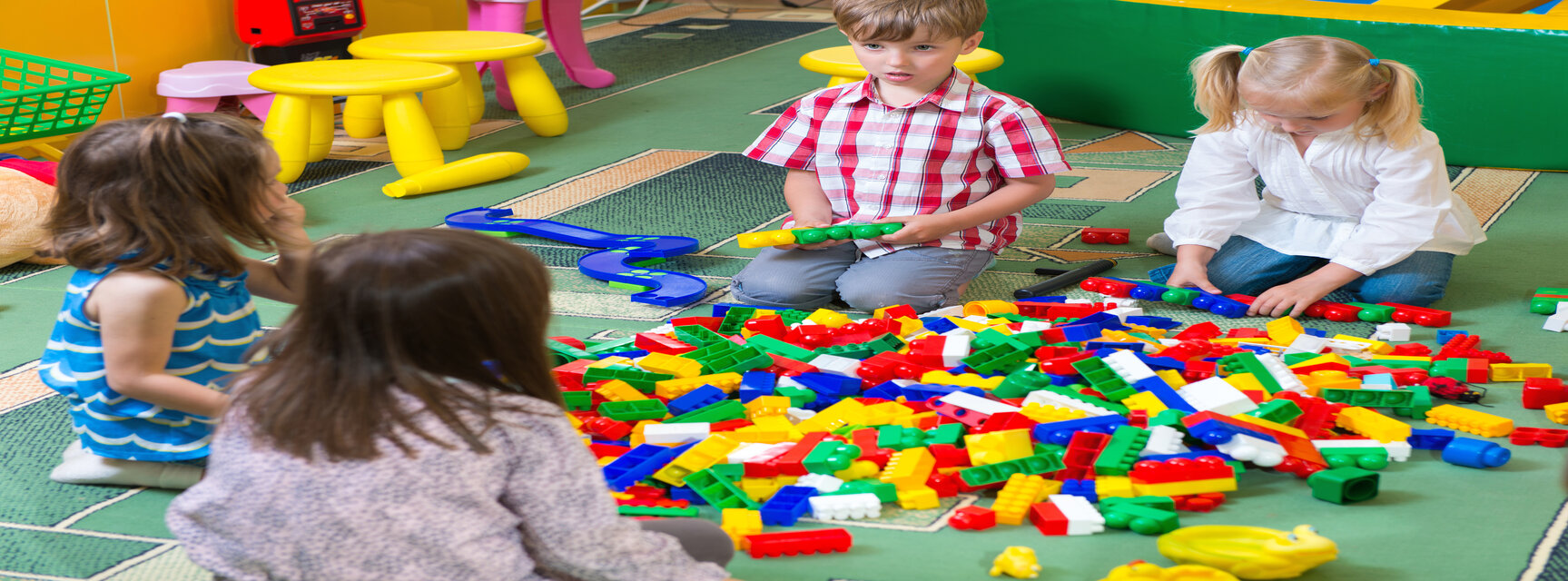 Kinder spielen mit bunten Bauelementen