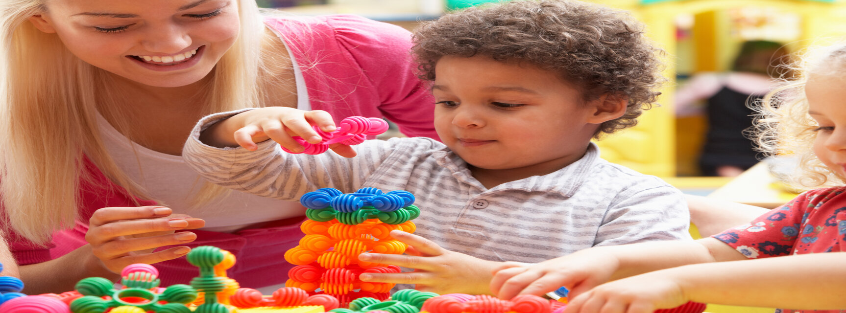 Spielende Kinder mit Aufsichtsperson