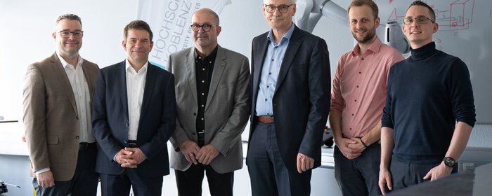 sechs Männer stehen zusammen