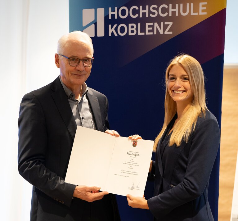 Präsident der Hochschule und Professorin mit Ernennungsurkunde