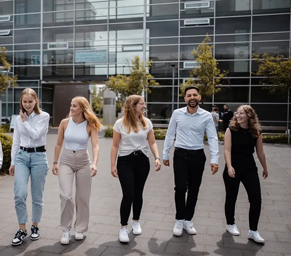 Gruppe Studierende laufen über den Innenhof