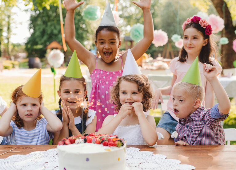 Kind mit Beeinträchtigung feiert mit seinen Freunden Geburtstag.