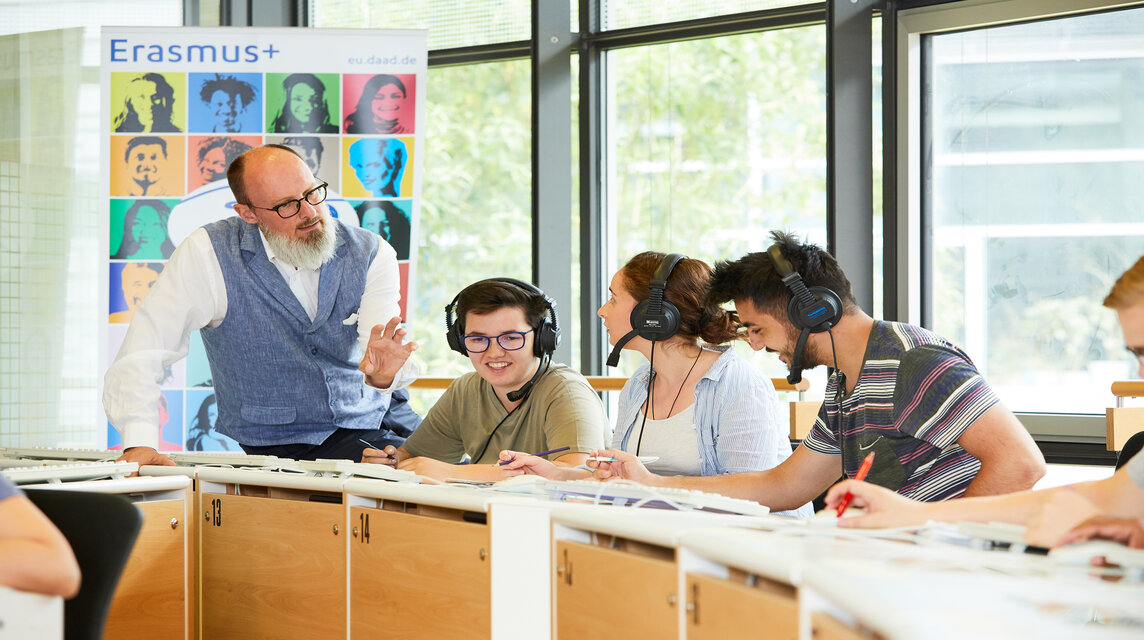 Dozent mit Studierenden im Sprachlabor