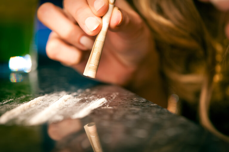 Young woman snorting cocaine