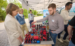 Infostand mit Menschen und technischen Geräten