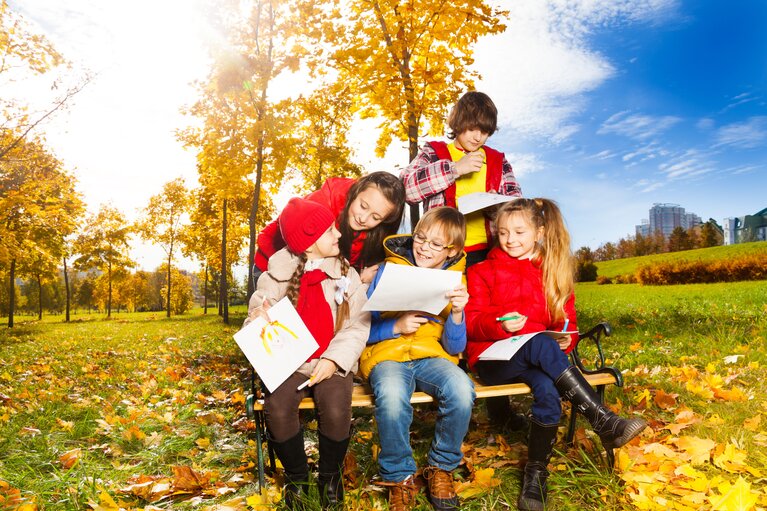 Kinder und Jugendliche auf einer herbstlichen Wiese.