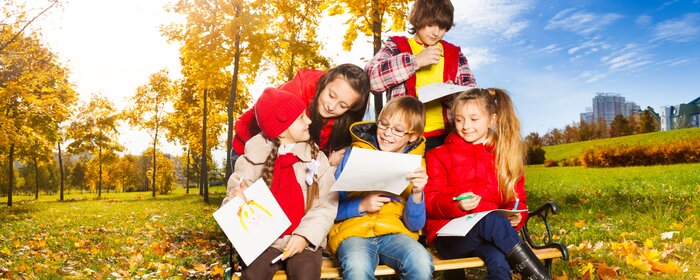 Kinder und Jugendliche auf einer herbstlichen Wiese.