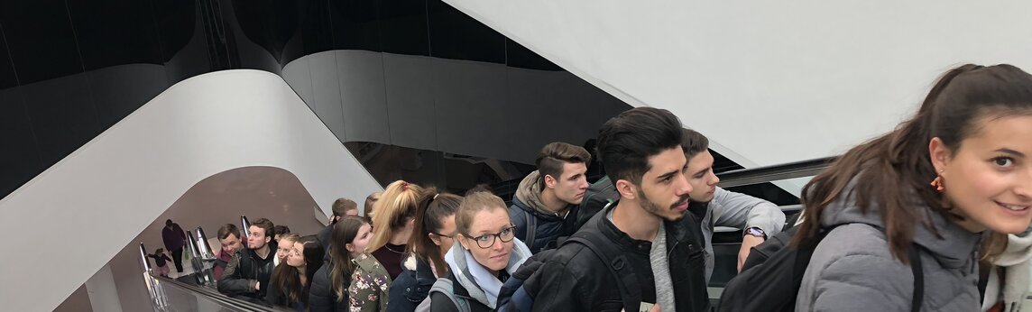 Studierende auf der Rolltreppe