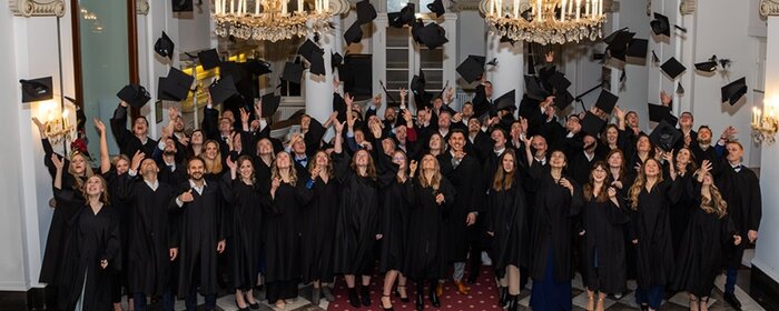 MBA-Absolvierende werfen ihre Hüte zur Feier des akademischen Abschlusses