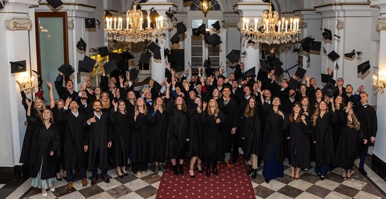 MBA-Absolvierende werfen ihre Hüte zur Feier des akademischen Abschlusses