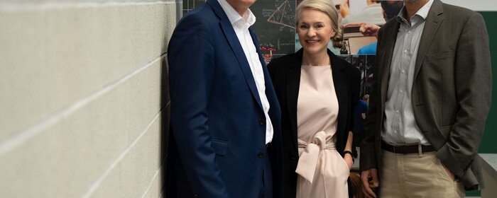 Zwei Männer und eine Frau (Mitte) stehen zusammen