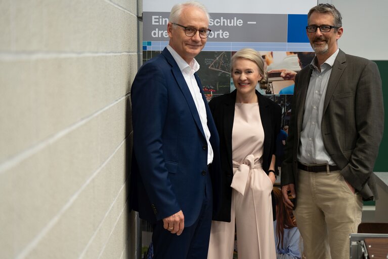 Zwei Männer und eine Frau (Mitte) stehen zusammen