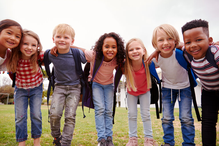 Portrait Of Excited Elementary School Pupils On Playing Field At Break Time