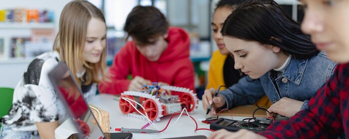 Gruppe von Schülerinnen und Schüler, die technisch arbeiten