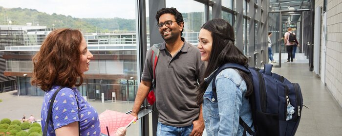 Drei Studierende im Gespräch auf einem Flur am Campus Remagen