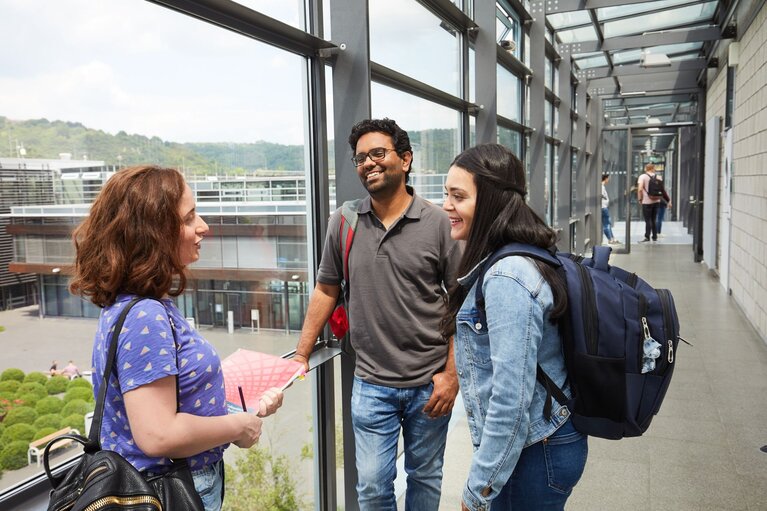 Drei Studierende im Gespräch auf einem Flur am Campus Remagen