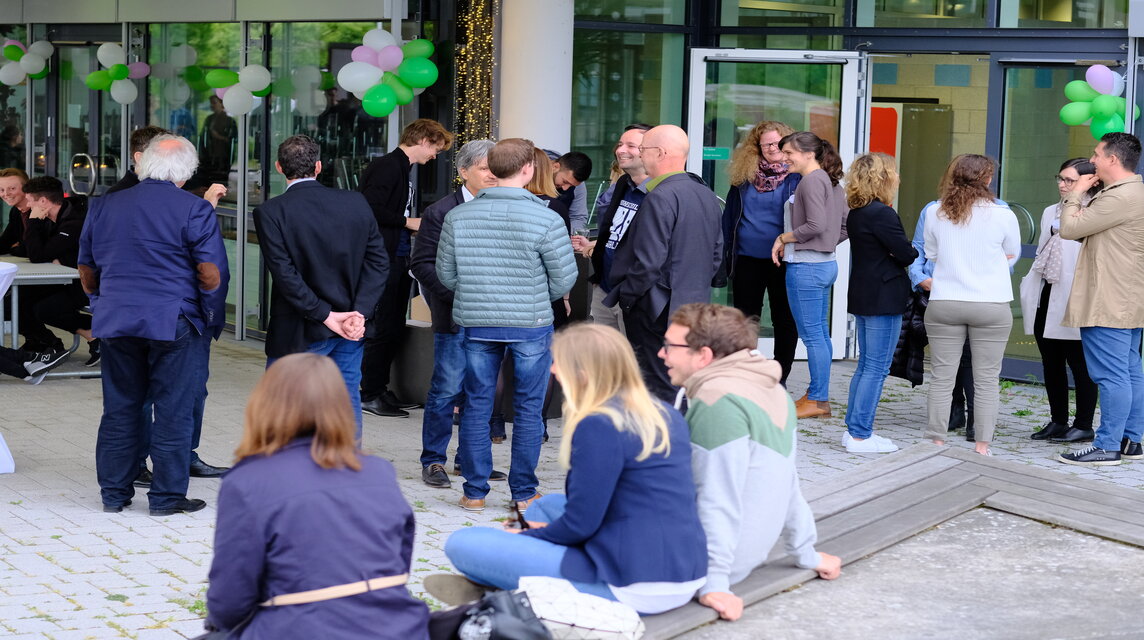 Alumnis stehen auf dem Hof und reden