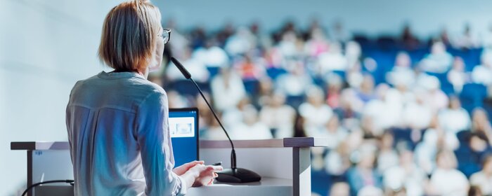Eine Frau im Hörsaal von hinten