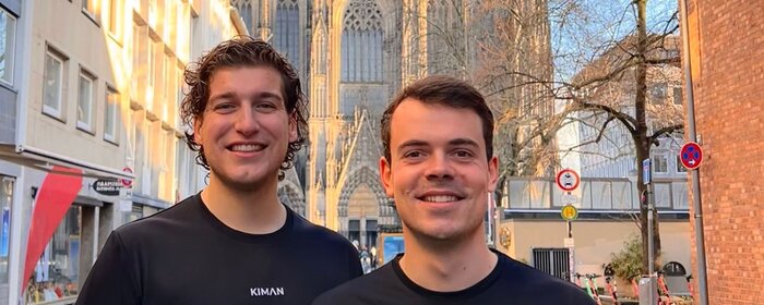 Zwei Männer stehen zusammen vor dem Kölner Dom.