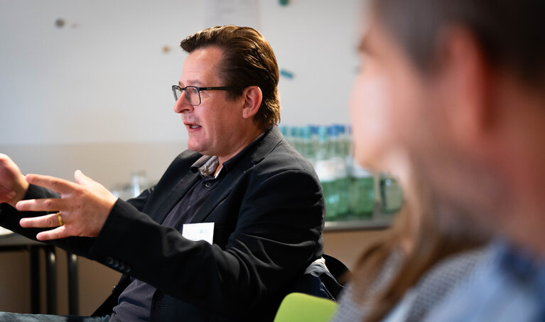 Ein Mann spricht und gestikuliert engagiert mit den Händen.