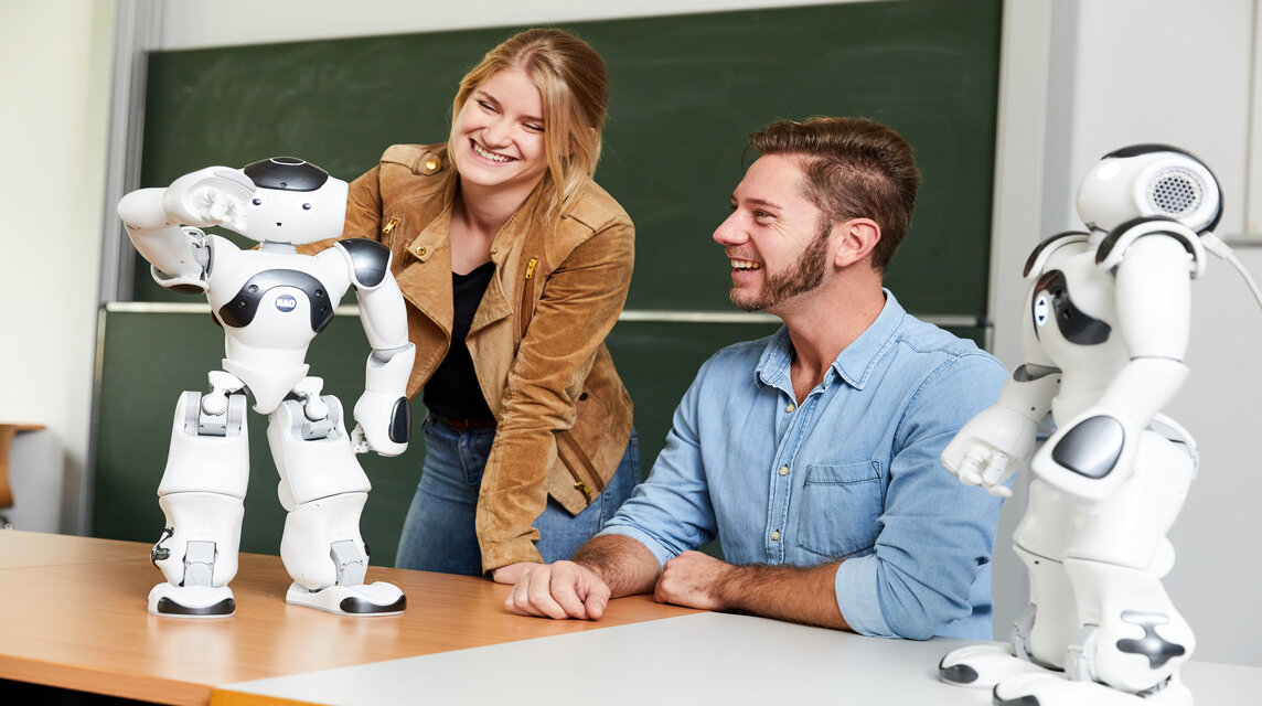 Zwei wissenschaftliche Mitarbeiter mit Robotern