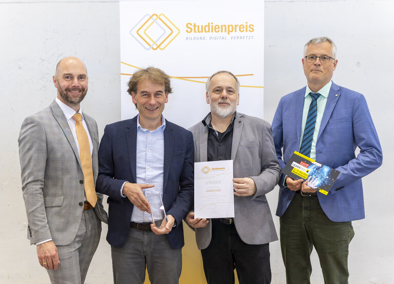Eine Gruppe von vier Männern vor einer Wand "Studienpreis. Bildung. Digital. Vernetzt"