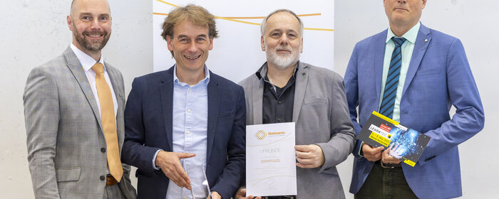 Eine Gruppe von vier Männern vor einer Wand "Studienpreis. Bildung. Digital. Vernetzt"
