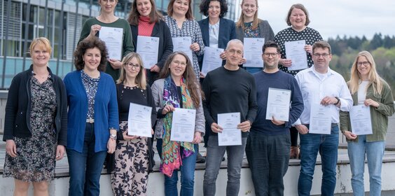 Die Teilnehmenden stehen als Gruppe im Außengelände der Hochschule zusammen.