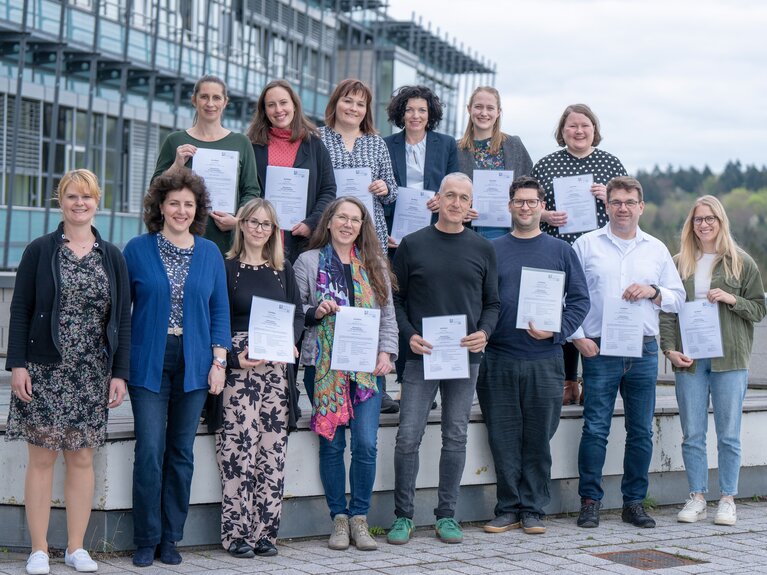 Die Teilnehmenden stehen als Gruppe im Außengelände der Hochschule zusammen.