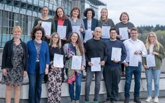 Die Teilnehmenden stehen als Gruppe im Außengelände der Hochschule zusammen.