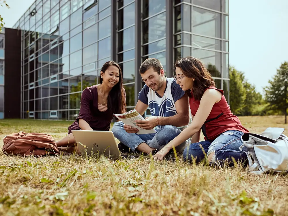 Campus Remagen Außenanlage Studierende im Gespräch auf einer Wiese am Campus Remagen