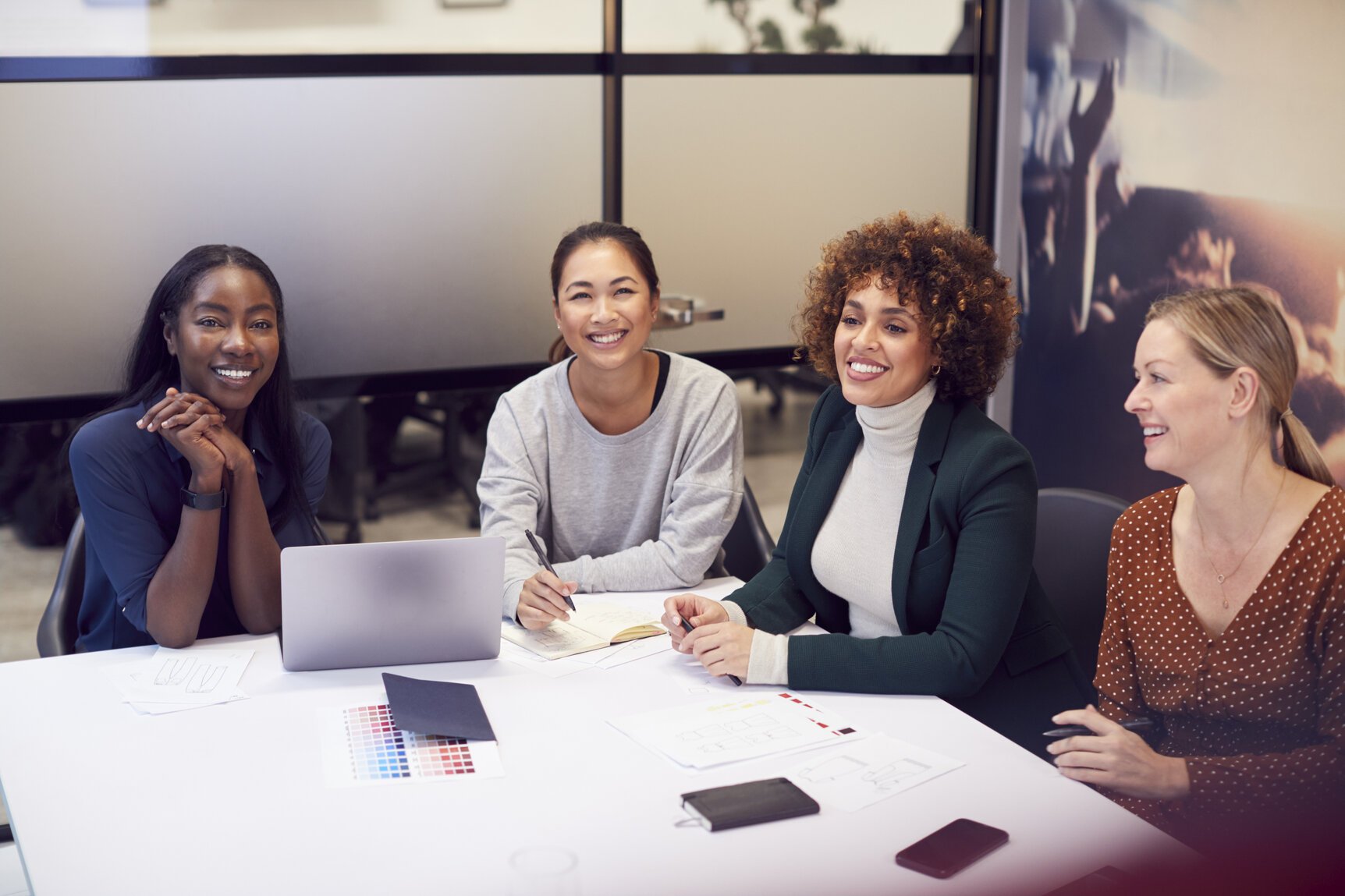 Group Of Businesswomen Collaborating In Creative Meeting Around Table In Modern Office