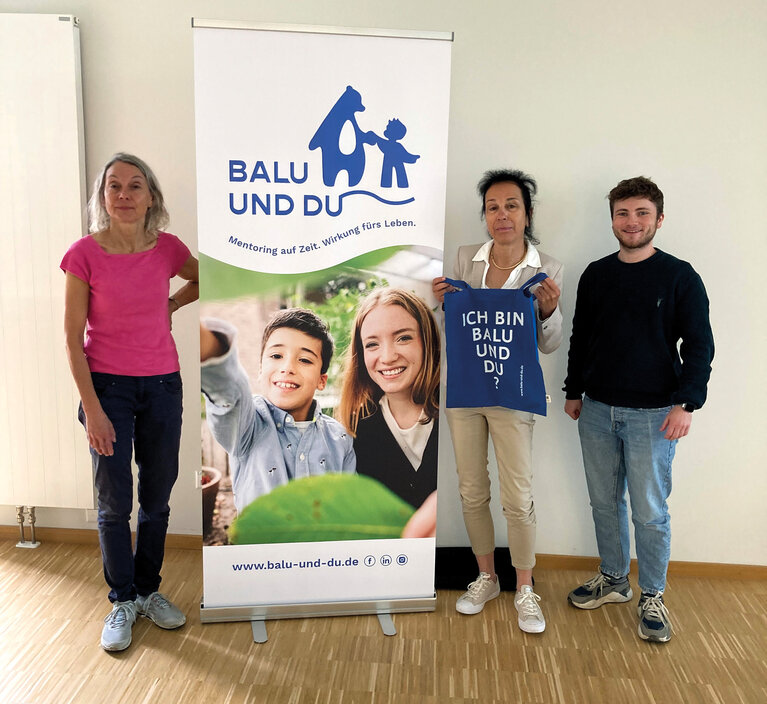 gruppenfoto Frau Marxen-Ney, Prof. Dr. Gabriele Moos und Ben Sander vor dem Rollup "Balu und Du"
