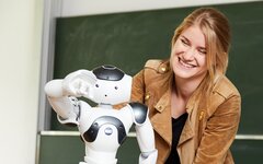 Mädchen sieht sich Roboter an