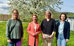 Vier Frauen stehen auf dem Gelände des Campus Remagen der Hochschule Koblenz vor einem blühenden Baum