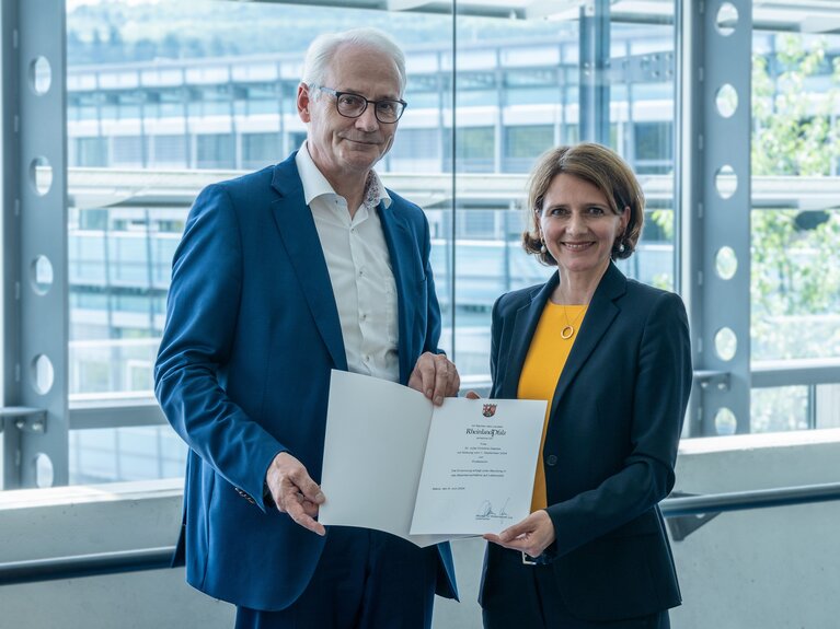 Ein Herr und eine Dame halten eine Urkunde in ihren Händen.