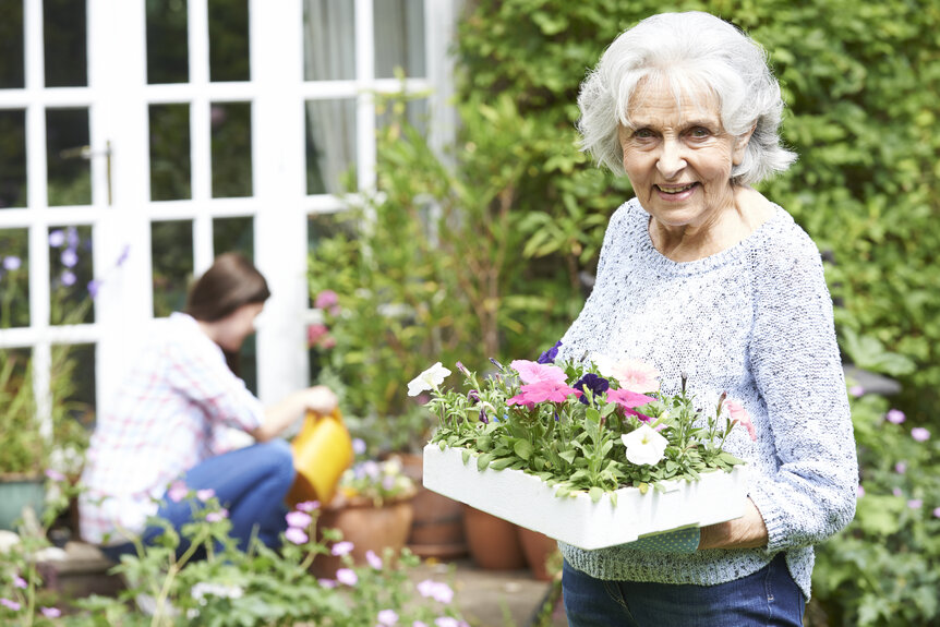 Studierende hilft Seniorin bei der Gartenarbeit