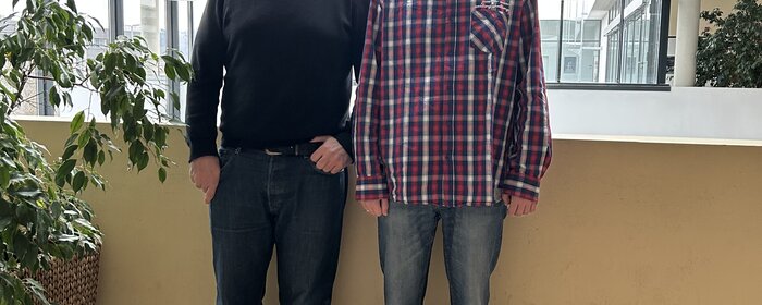Zwei Männer stehen zusammen.