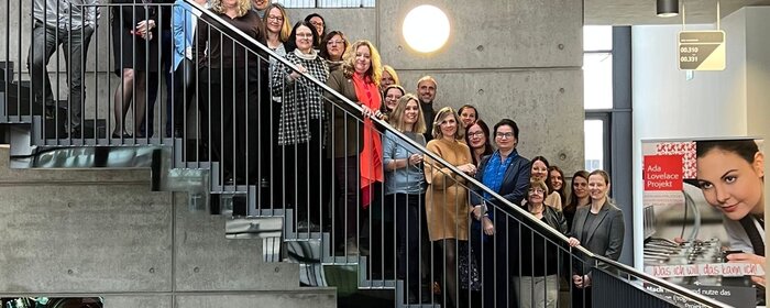 Frauen und Männer auf einer Treppe.