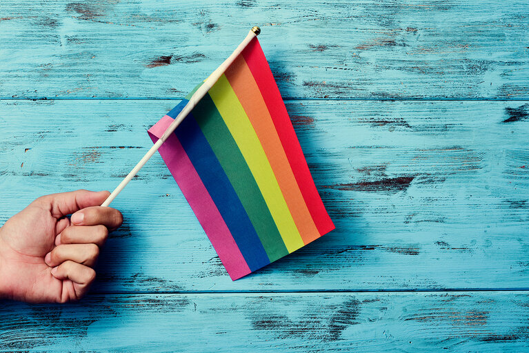man waving a small rainbow flag