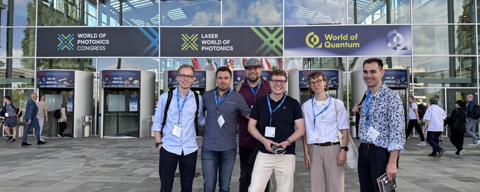 Eine Gruppe von Studierenden steht vor der Messehalle.