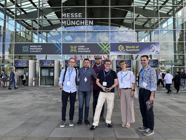 Eine Gruppe von Studierenden steht vor der Messehalle.