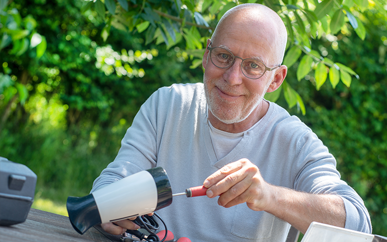Ein Mann repariert ein Elektrogerät.
